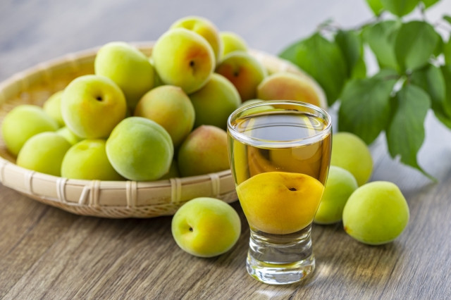 glass of umeshu and a basket of plums