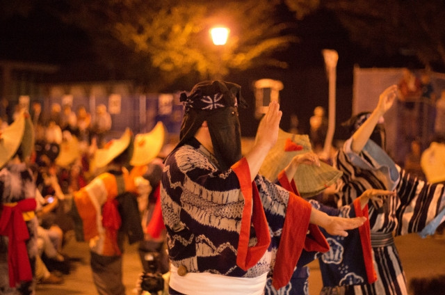 male nishimonai bon odori dancer with face covered by hikosazuki black hood