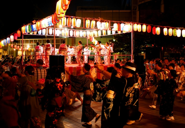 bon odori dancing scene with people dancing around the yagura stage