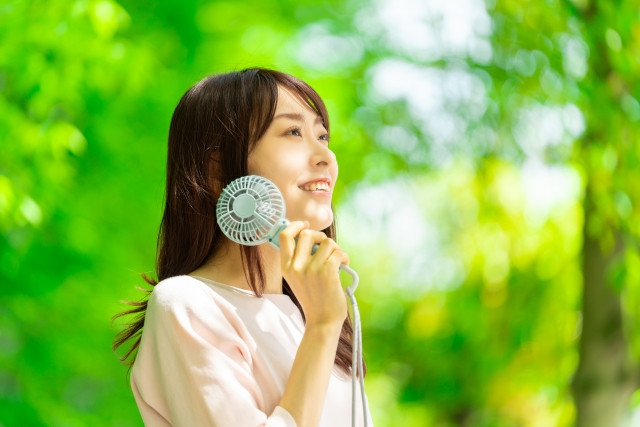 woman keeping cool with a handy fan