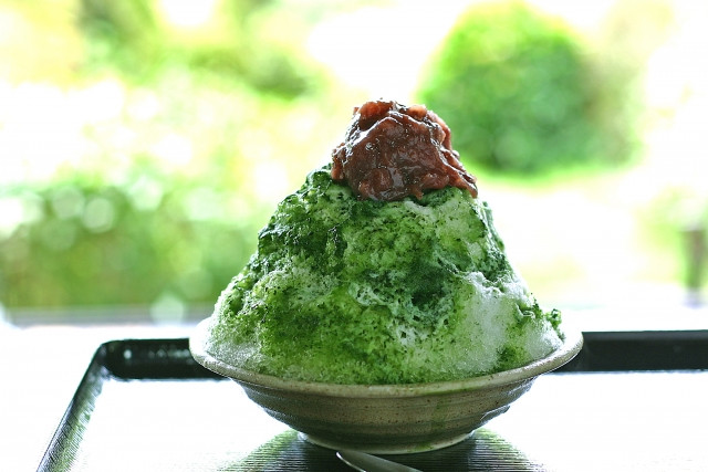 A bowl of matcha kakigori with red bean topping