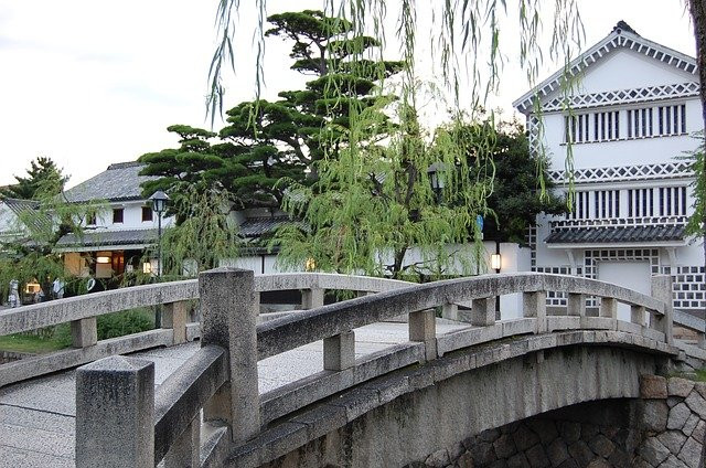 Stone bridge and white walled kominka 
