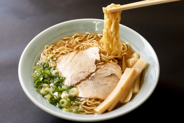 A hearty bowl of ramen topped with chashu and spring onions