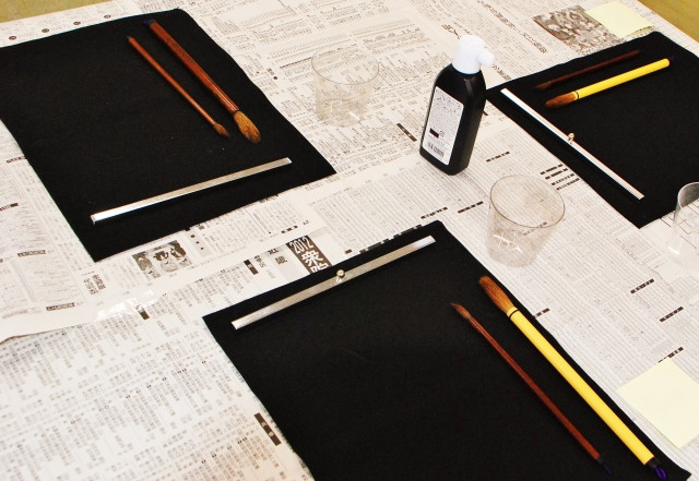 Essential calligraphy tools - brush, ink, newspaper