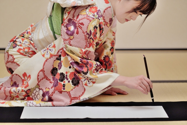 Kimono clad lady preparing to write kakizome