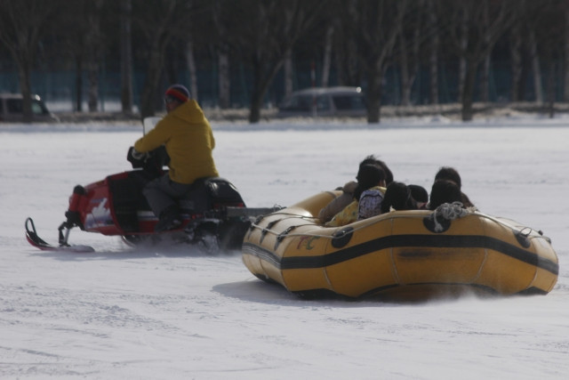 family having fun snow rafting