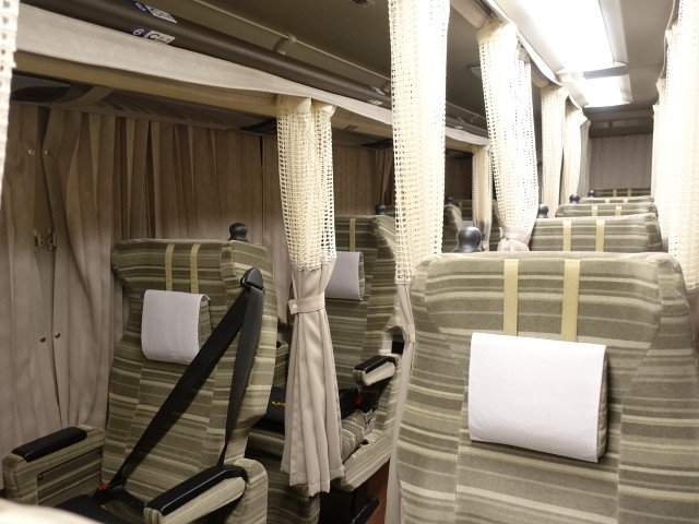 interior of highway bus with curtains for each seat and individual seating